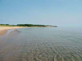 Clear water, blue sky, empty beach.